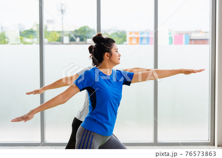 Two Asian women sporty attractive people practicing yoga lesson together 76573863