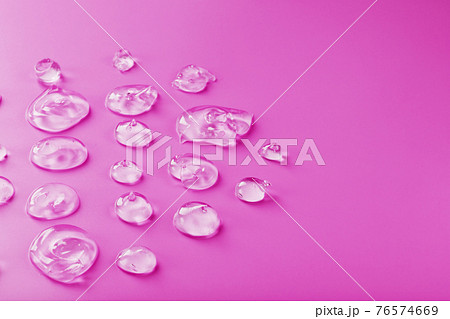 Transparent drops of Gel on a pink background with free space. Transparent drops of Gel on a pink background with free space. 76574669