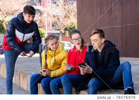 Teenagers are playing on smartphone on street Teenagers are playing on smartphone on street 76576970