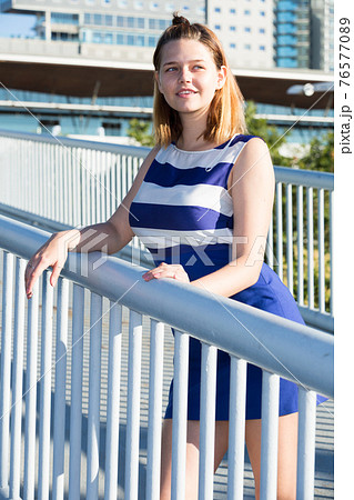 Girl posing on city bridge in summer day 76577089