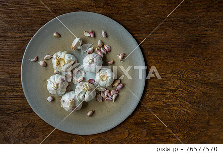 Garlic bulbs and Garlic cloves in Ceramic plate on Wooden rustic table. Garlic bulbs and Garlic cloves in Ceramic plate on Wooden rustic table. 76577570