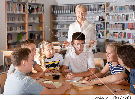 Group of nice schoolers discussing with teacher 76577633