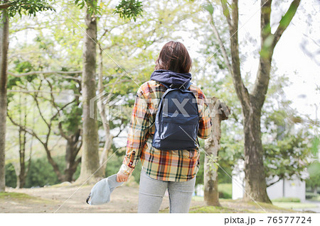 登山道を歩く一人の女性の後ろ姿 76577724