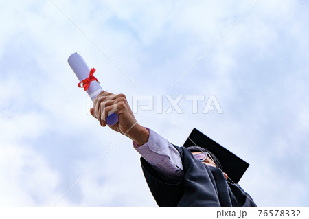 Student with congratulations, graduates wearing a graduation gown of university. 76578332