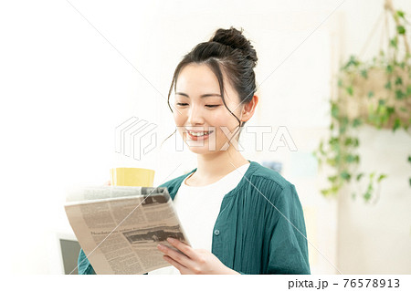 英字新聞を読む女性 英字新聞を読む女性 76578913