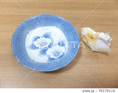 食器洗いの前に皿の汚れを拭く　カレーライスを食べ終わった皿　 76579110