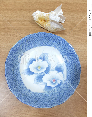 食器洗いの前に皿の汚れを拭く　カレーライスを食べ終わった皿　 76579111
