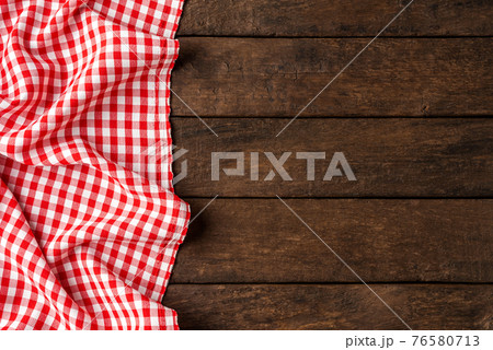 Red checkered tablecloth on wooden background 76580713