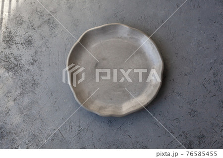 Stone curl gray platter on conrete table Stone curl gray platter on conrete table 76585455