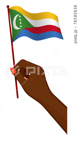 Female hand gently holds small flag of Comoros islands. Holiday design element. Cartoon vector on white background