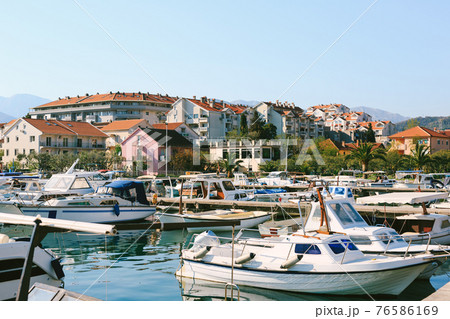 Boat pier in Tivat, Montenegro. Small fishing and pleasure boats are moored in the marina. Boat pier in Tivat, Montenegro. Small fishing and pleasure boats are moored in the marina. 76586169