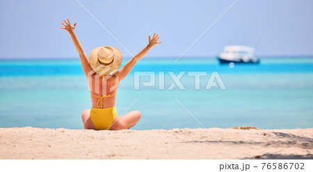 Woman enjoying exotic resort on beach 76586702