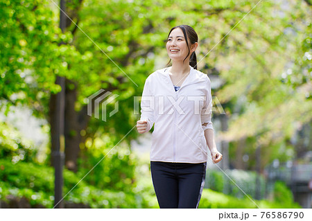 笑顔でジョギングする若い女性 76586790