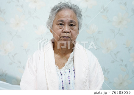Asian senior or elderly old lady woman patient sitting on bed in nursing hospital ward with hope and waiting her relative Asian senior or elderly old lady woman patient sitting on bed in nursing hospital ward with hope and waiting her relative 76588059