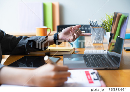 Close up Hand of Businesswoman pointing and analyzing charts by document and laptop computer. Close up Hand of Businesswoman pointing and analyzing charts by document and laptop computer. 76588444