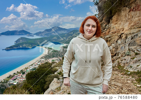 Lycian Trail in Blue Lagoon area of Oludeniz village near Fethiye, young white woman with red hair poses against backdrop of landscape. Lycian Trail in Blue Lagoon area of Oludeniz village near Fethiye, young white woman with red hair poses against backdrop of landscape. 76588480