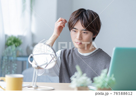 自宅のリビングの鏡の前でヘアスタイルを気にするZ世代 76588612