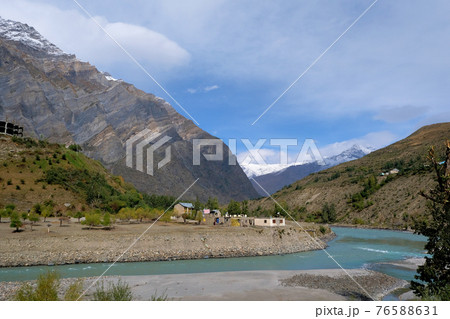 A cozy little village on the banks of a turquoise river in the mountains of the Himalayas on a clear autumn day A cozy little village on the banks of a turquoise river in the mountains of the Himalayas on a clear autumn day 76588631