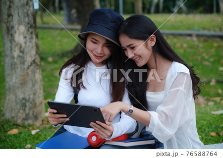 Friends or Family concept. Two Female using maps on tablet while travel. Friends or Family concept. Two Female using maps on tablet while travel. 76588764
