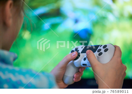 Girl playing video game with joystick at home Girl playing video game with joystick at home 76589011