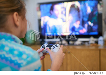 Girl playing video game with joystick at home Girl playing video game with joystick at home 76589014