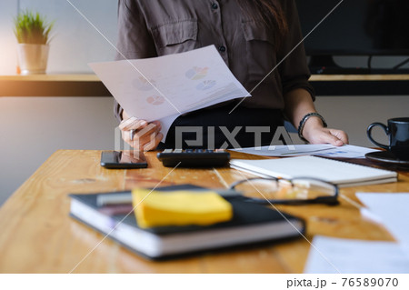 Close up Hand of Businesswoman pointing and analyzing charts by document. Close up Hand of Businesswoman pointing and analyzing charts by document. 76589070