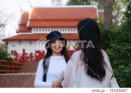 Asian woman traveler with backpack using maps on tablet and sitting in park, travel holiday relaxation concept Asian woman traveler with backpack using maps on tablet and sitting in park, travel holiday relaxation concept 76589087