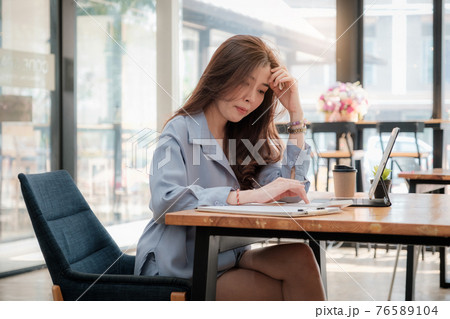 Young asian accountant using calculations. Savings, finances, tax and economy concept. 76589104