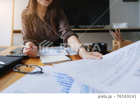 Close up Hand of Businesswoman pointing and analyzing charts by document. 76589241
