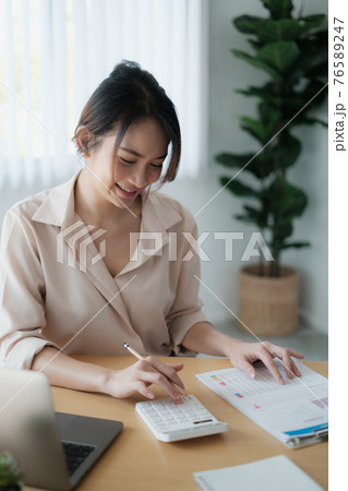 Asian Business woman accountant or banker use calculator and audit finance planning sales to meet targets. 76589247