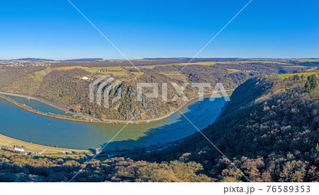 Panoramic drone image of the Loreley rock on the Rhine river taken from the opposite side of the Rhine under blue sky and sunshine 76589353