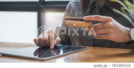 Online Shopping. Asian woman typing credit card information by tablet keyboard for shopping online. 76589410