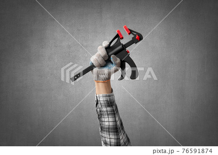 hand holds a construction tool clamp hand holds a construction tool clamp 76591874