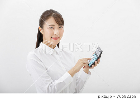 電卓をたたく女性 76592258