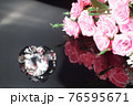 Three excellent diamonds of the first water and bouquet of pink roses with reflection on black mirror background close up view. Jewelry diamonds sale, invitation, action, discount banner, poster 76595671