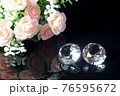 Couple of wonderful pure diamonds and bouquet of tea roses with reflection on black mirror background close up view. Jewelry diamonds sale, invitation, action, discount banner, poster template 76595672