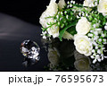 Excellent diamond of the first water and bouquet of white roses with reflection on black mirror background close up view. Jewelry diamonds sale, invitation, action, discount banner, poster template 76595673