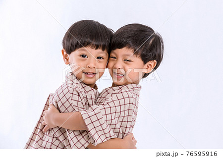 Twin boys hugging  on white background. Portrait of little son hugging brother or friend. 76595916