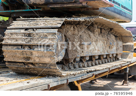 Excavator tracks. Old iron caterpillars of the bulldozer of the tractor on the road Excavator tracks. Old iron caterpillars of the bulldozer of the tractor on the road 76595946