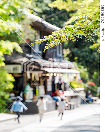 情緒豊かな春の門前町周辺の景色　新緑のモミジと茶屋の前を行く子ども達の風景 76596869