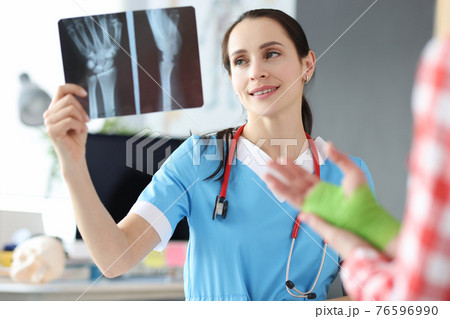Doctor examines patient hand injury on an X-ray 76596990