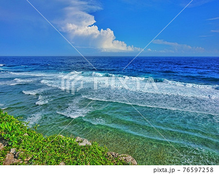 青空に浮かぶ雲と青い海の風景 76597258