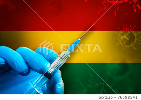 Bolivia Covid-19 Vaccination Campaign. Hand in a blue rubber glove holds a syringe with covid-19 virus vaccine in front of Bolivia flag 76598541