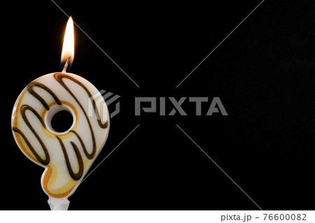 Number 9 birthday celebration donut candle a black background. Copy space for text 76600082