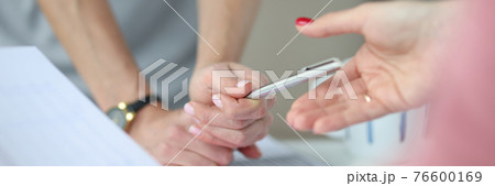 Above work table, hands and a pen on table are charts with business figures Above work table, hands and a pen on table are charts with business figures 76600169