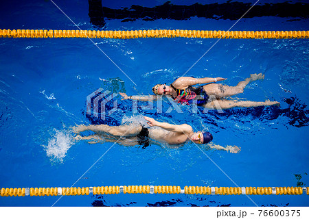 Training of professional swimmers. Athletes swim on their backs in the pool. Training of professional swimmers. Athletes swim on their backs in the pool. 76600375