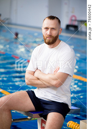 A young swimming coach near the sports pool. 76600442