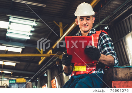 Manufacturing worker working with clipboard to do job procedure checklist . Manufacturing worker working with clipboard to do job procedure checklist . 76602076