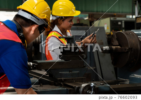Group of skillful workers using machine equipment in factory workshop Group of skillful workers using machine equipment in factory workshop 76602093