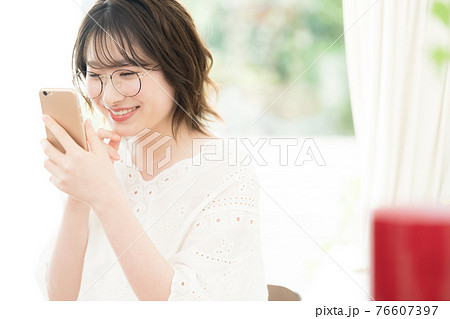スマートフォンを見る若い女性 スマートフォンを見る若い女性 76607397